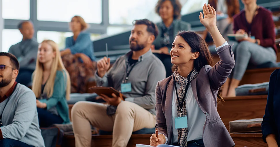 empower through education Smiling woman raising her hand at a professional conference or seminar