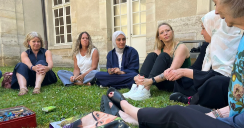image 4 1x Diverse group of women sitting on grass in a circle, engaged in outdoor conversation